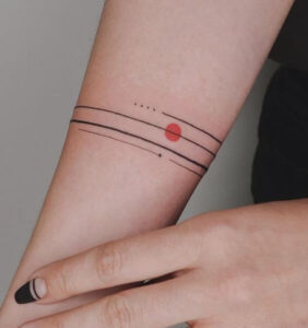 tatuaggio donna sul braccio con linee e punto rosso