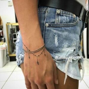 tatuaggio donna braccialetto sul polso con croci
