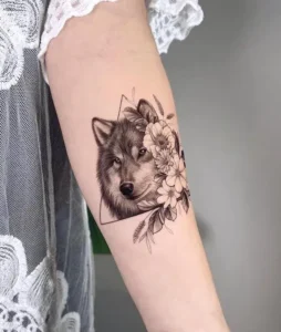 tatuaggio sul braccio testa di lupo con fiore