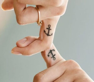 tatuaggio piccolo ancora sul dito coppia