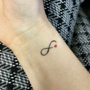 tatuaggi piccoli significativi simbolo infinito con cuore sul braccio polso