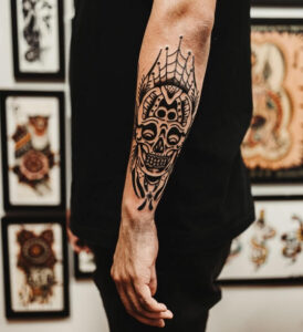 tatuaggio uomo sul gomito teschio con rete