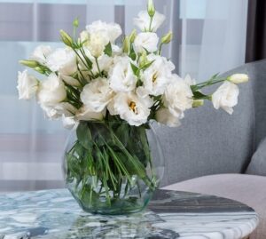 fiori lisianthus bianchi in un vaso sopra un tavolino di un salotto