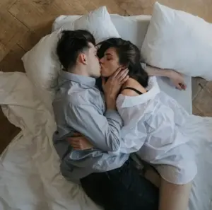 uomo e donna che si baciano affettuosamente nel letto